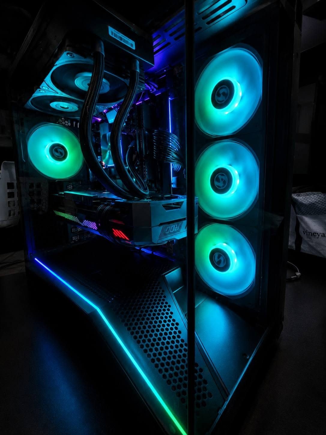 Custom PC tower glowing with teal and cyan RGB fans
